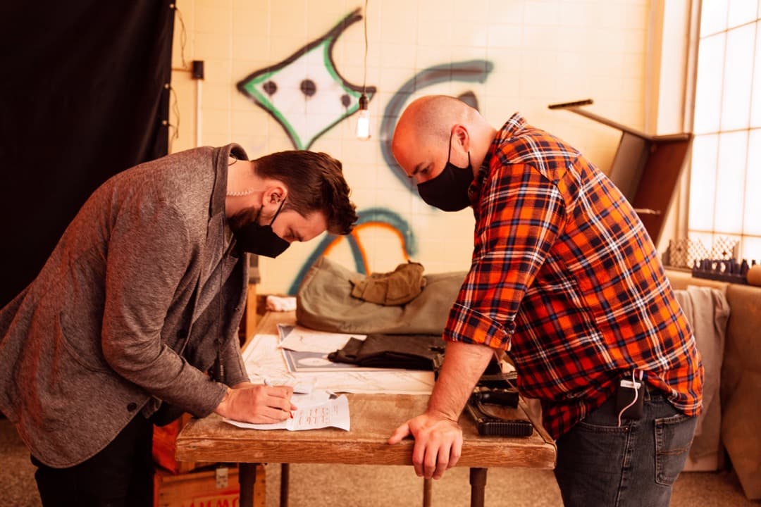 Behind the scenes photo 67 from Clone Cops production showing 1st ad nate eggert and director danny dones discuss schedules for clone cops